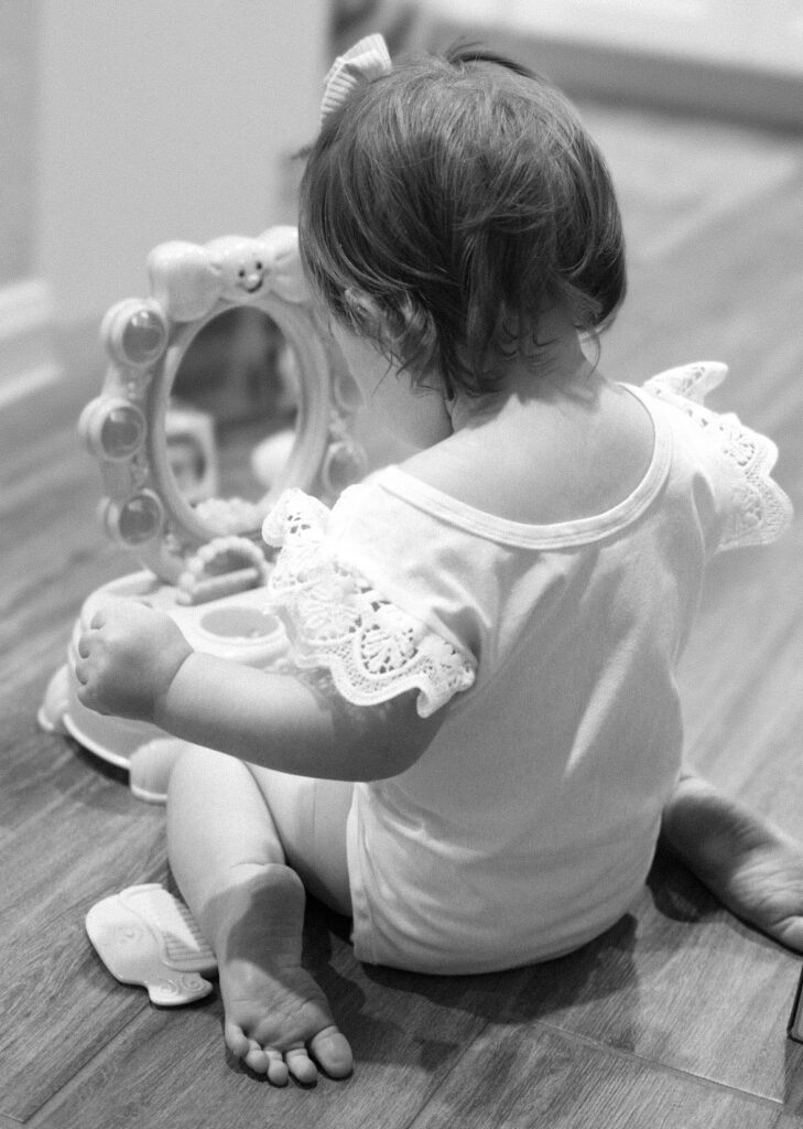 Small girl looking at her reflection in mirror
