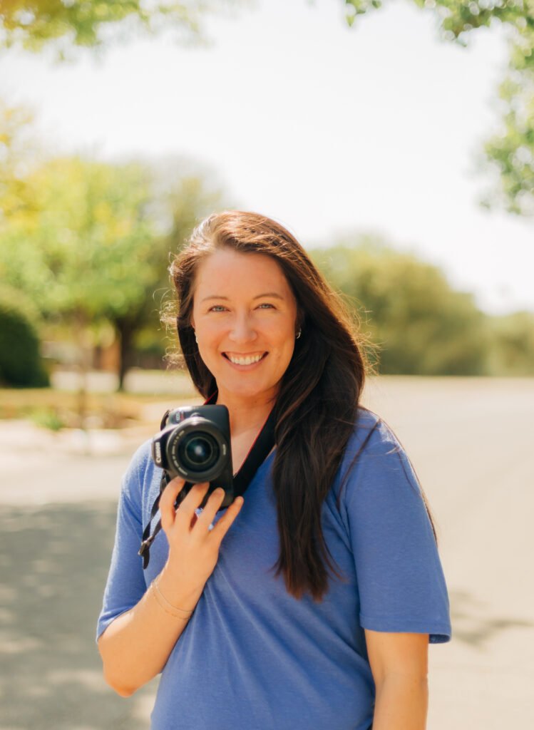 Wedding photographer holding camera and smiling