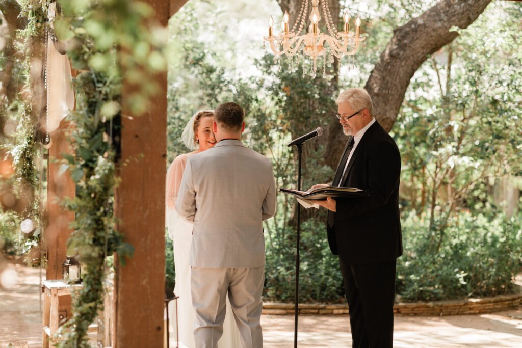 Bride and groom repeat vows from officiant during wedding ceremony