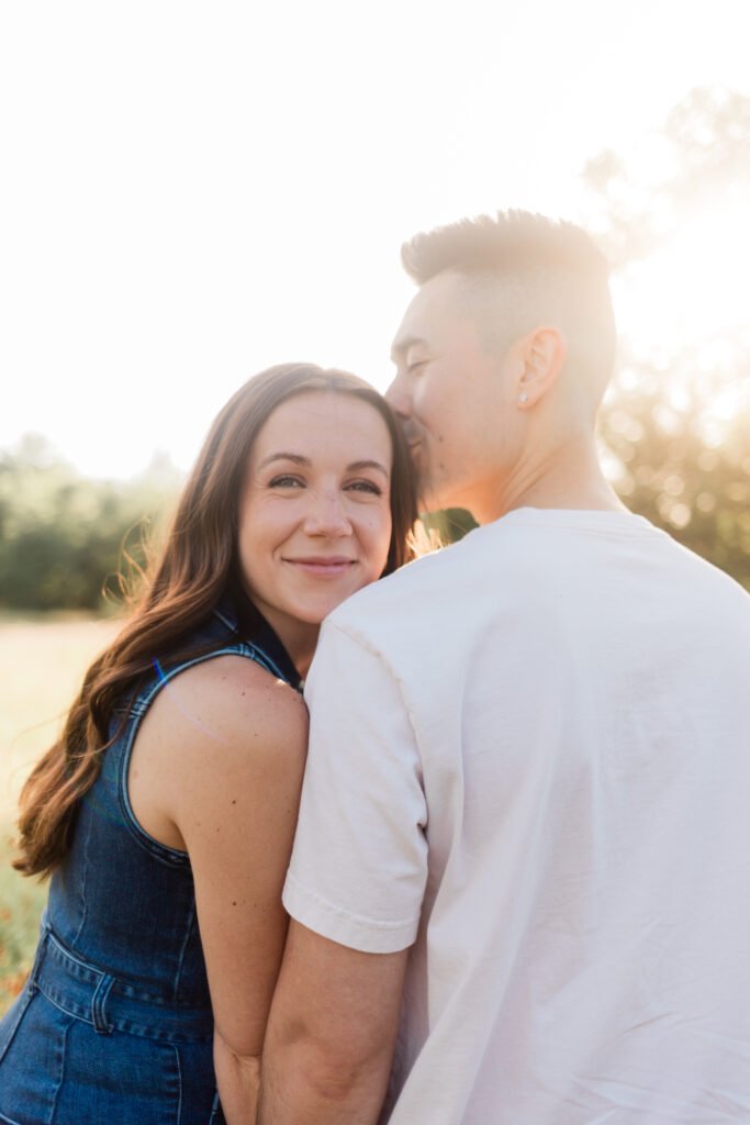 engagement Engaged couple sharing a kiss on the cheek during photography session