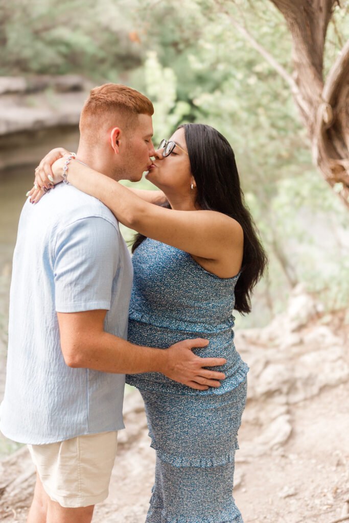Couple kisses during maternity photo session.
