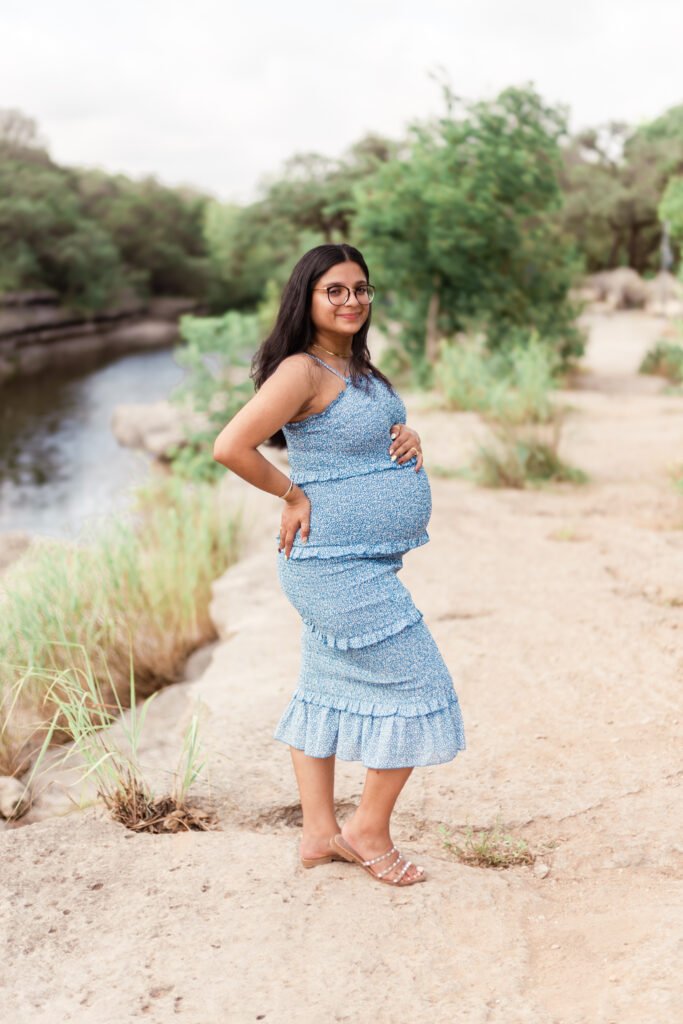 Woman holds her pregnant stomach for maternity session