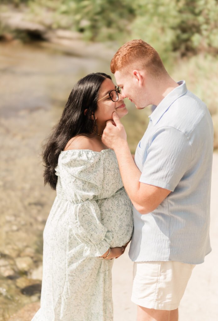 Husband kisses wife during maternity session