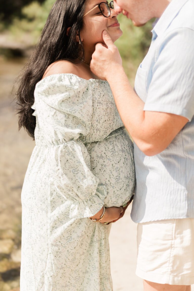 Man and woman kiss during maternity session