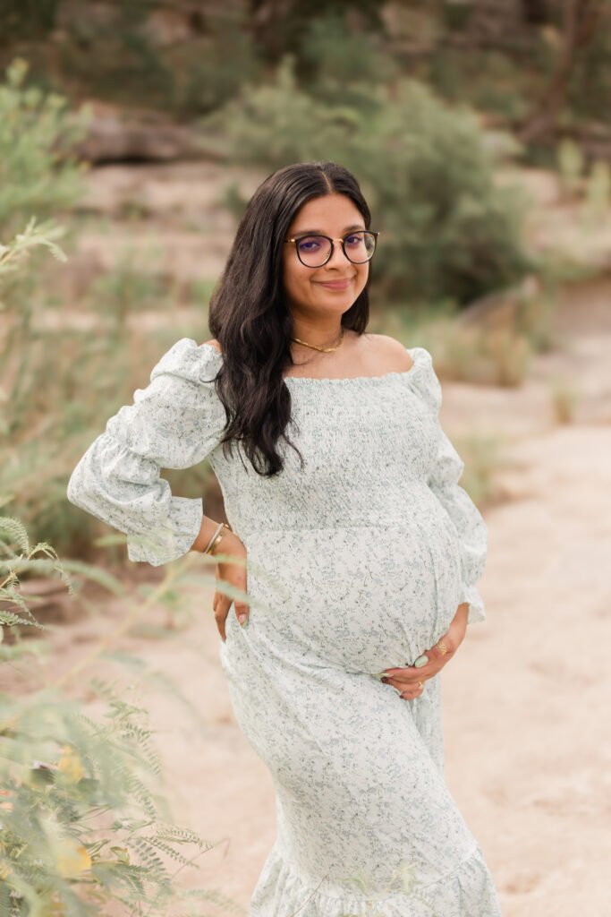 Pregnant woman holds her stomach for maternity photoshoot