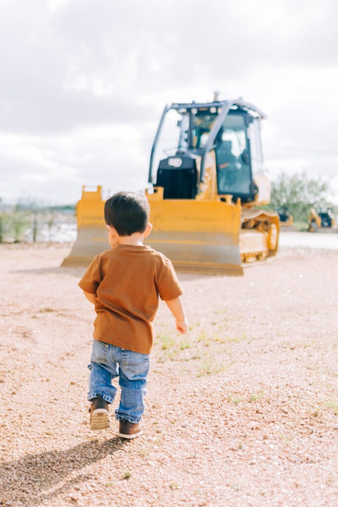 Young boy runs toward favorite tractor during birthday photoshoot