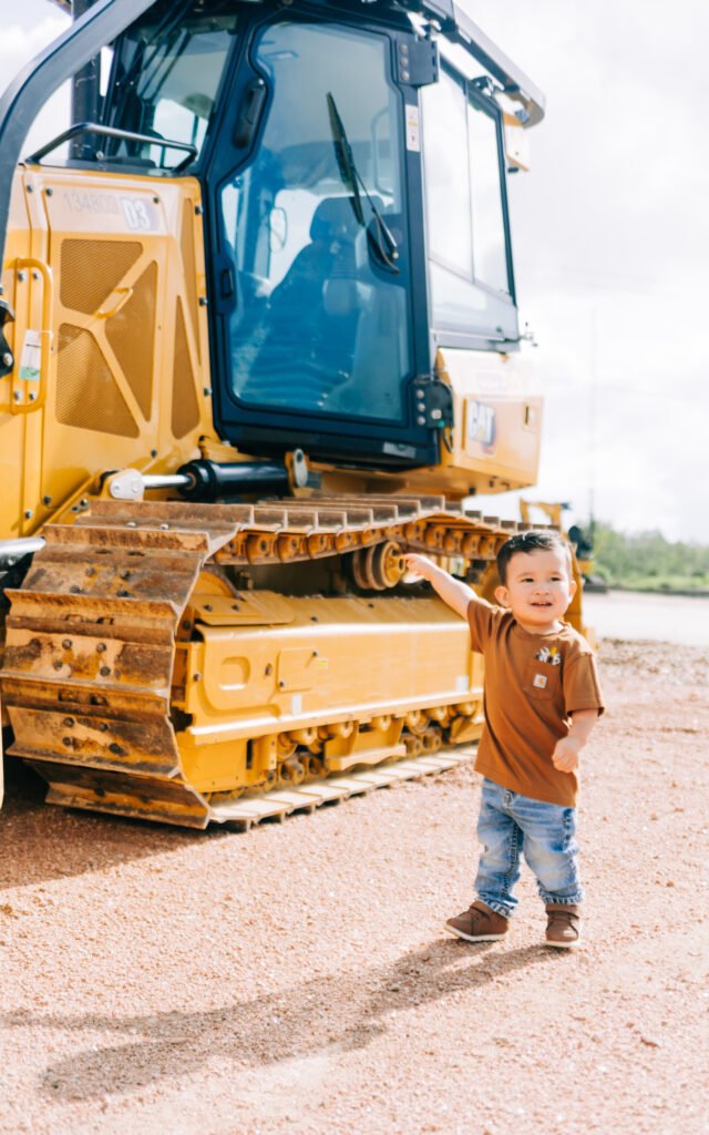 Young boy points at favorite tractor during birthday photoshoot
