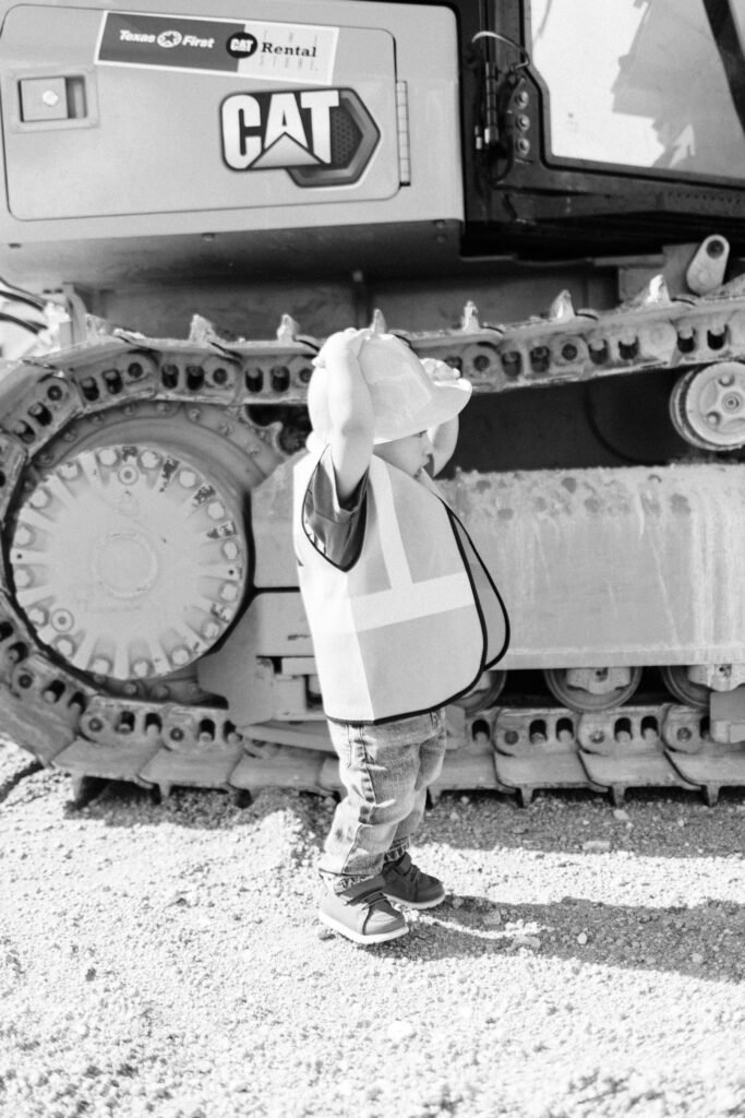 Toddler putting on construction hat during birthday photoshoot