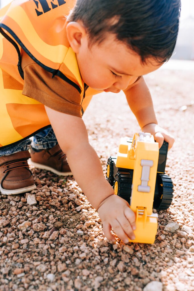 Toddler playing with toy tractor during birthday photoshoot