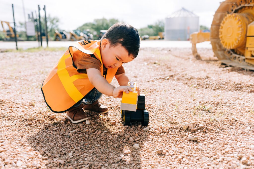 Toddler playing with toy tractor during birthday photoshoot