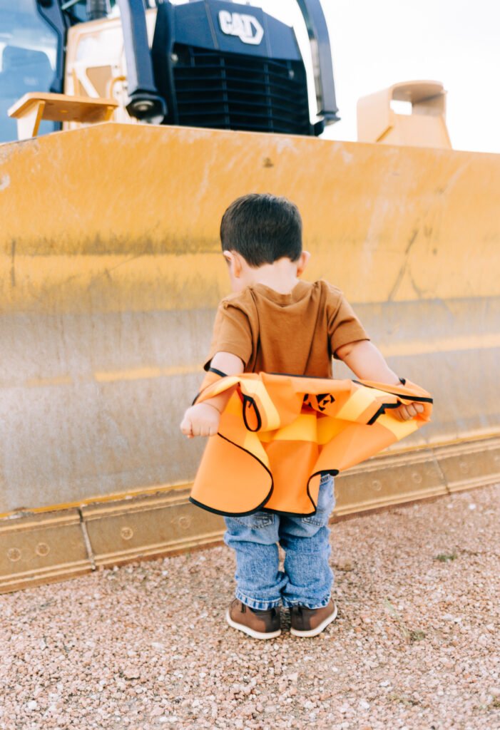 Toddler putting on vest during birthday photoshoot