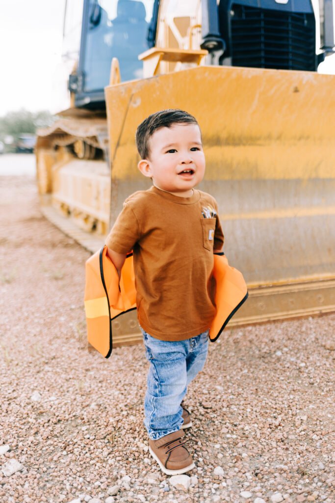 Toddler taking off vest during birthday photoshoot