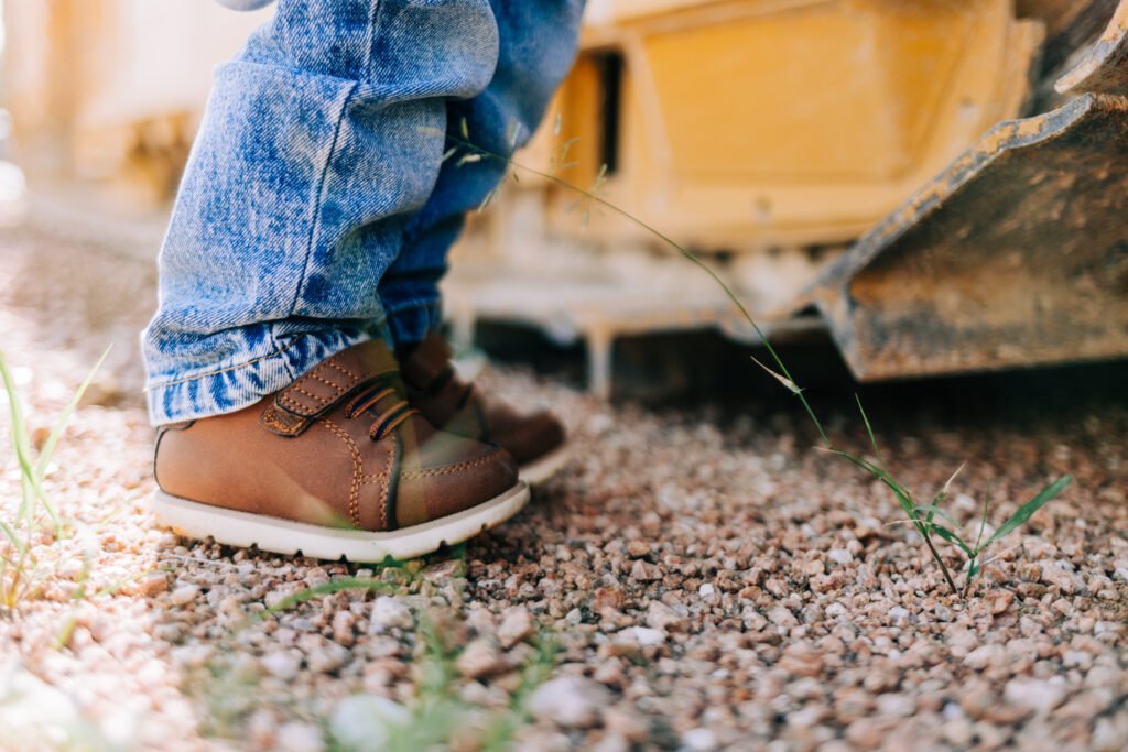 Toddler's shoes standing by tractor