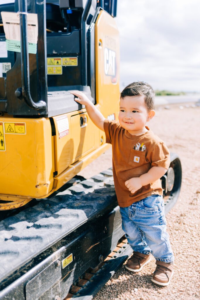 Birthday photoshoot where boy is posing by tractor