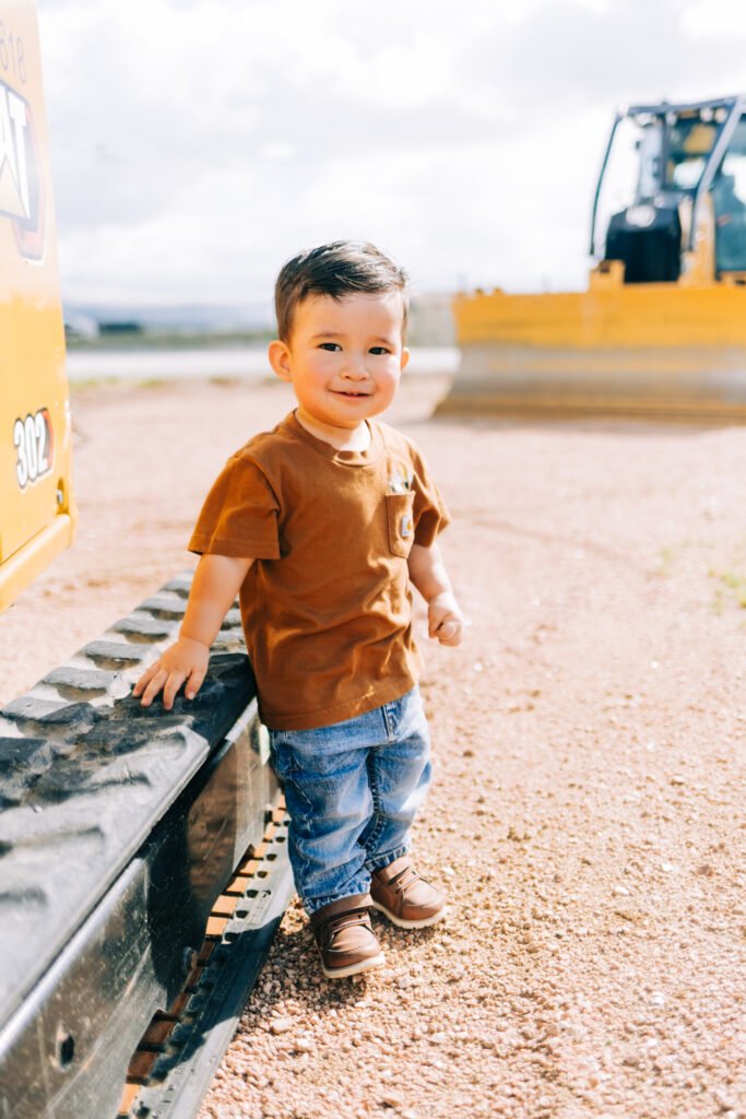 Young boy smiling on tractor for birthday photoshoot