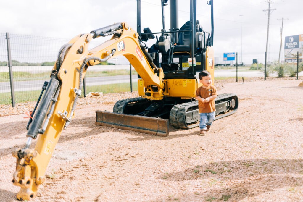 Young boy laughing in front of tractor for birthday photoshoot