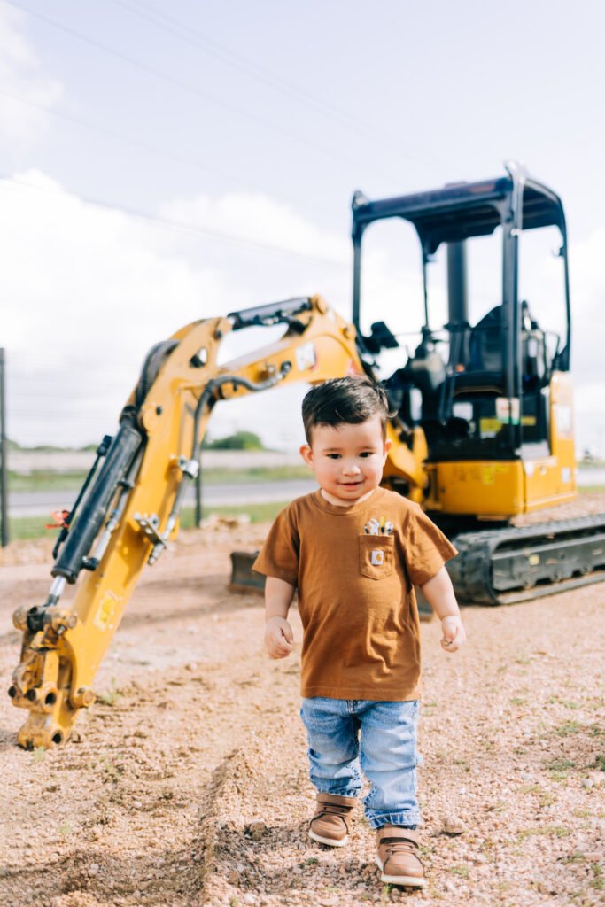 Toddler walking in front of tractor during birthday photoshoot