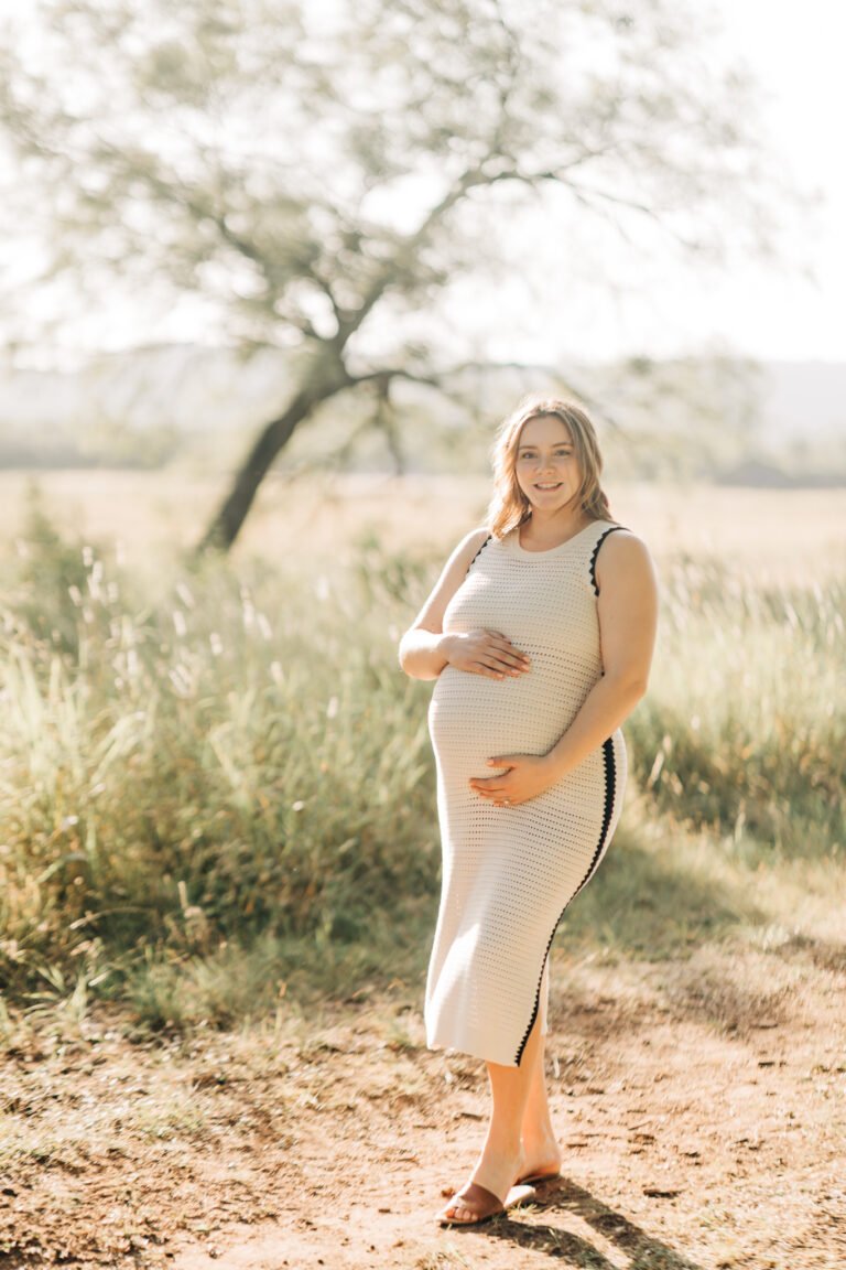 Woman holds pregnant stomach during maternity session in Buffalo Gap, Tx