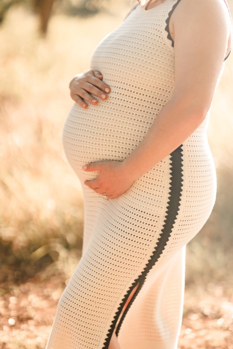 Woman holds pregnant stomach during maternity session in Buffalo Gap, Tx