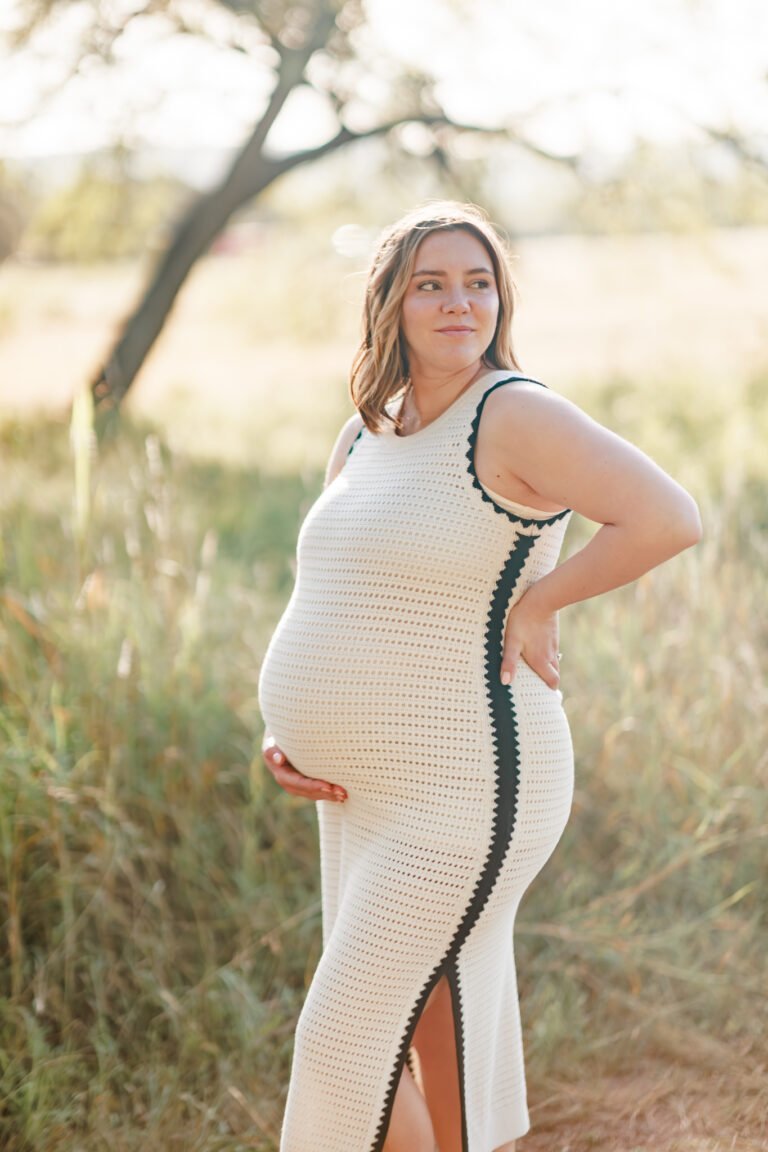 Woman holds pregnant stomach during maternity session in Buffalo Gap, Tx