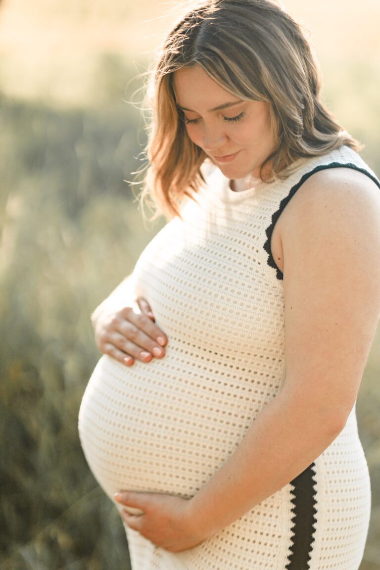 Woman holds pregnant stomach during maternity session in Buffalo Gap, Tx