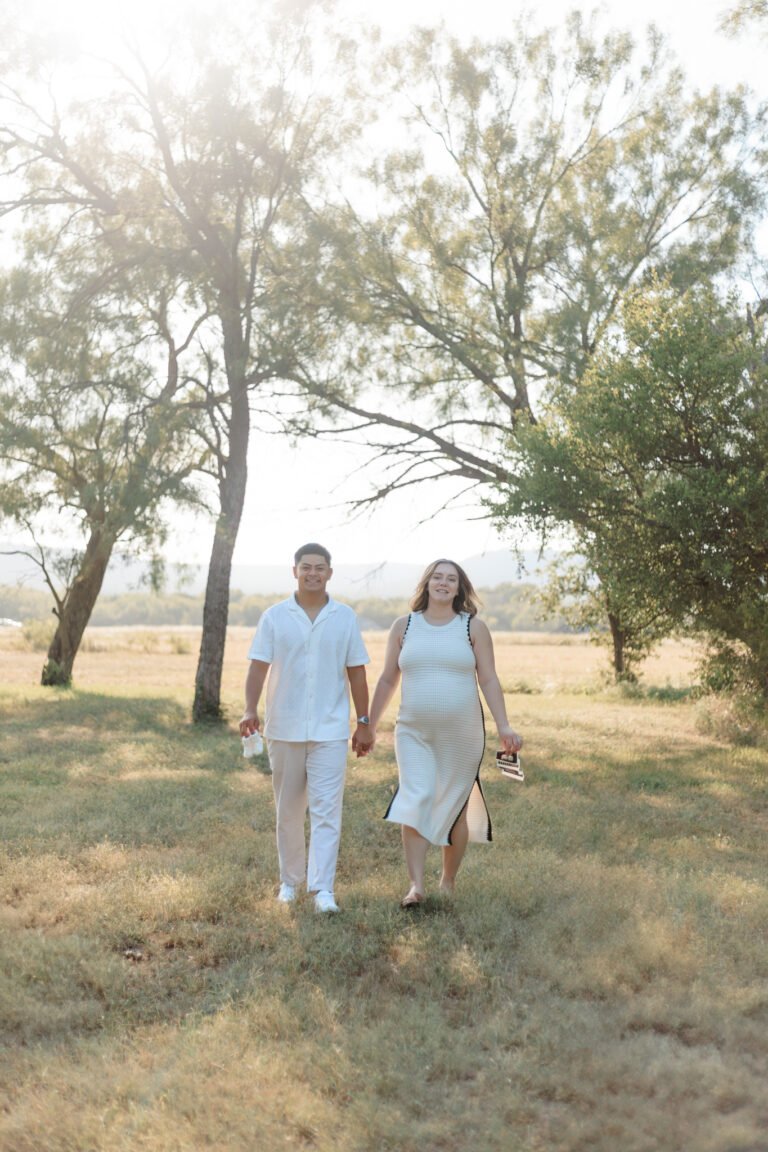 Couple walks holding hands in field of Buffalo Gap, Tx
