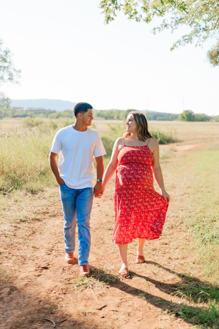 Couple walks holding hands in field of Buffalo Gap, Tx