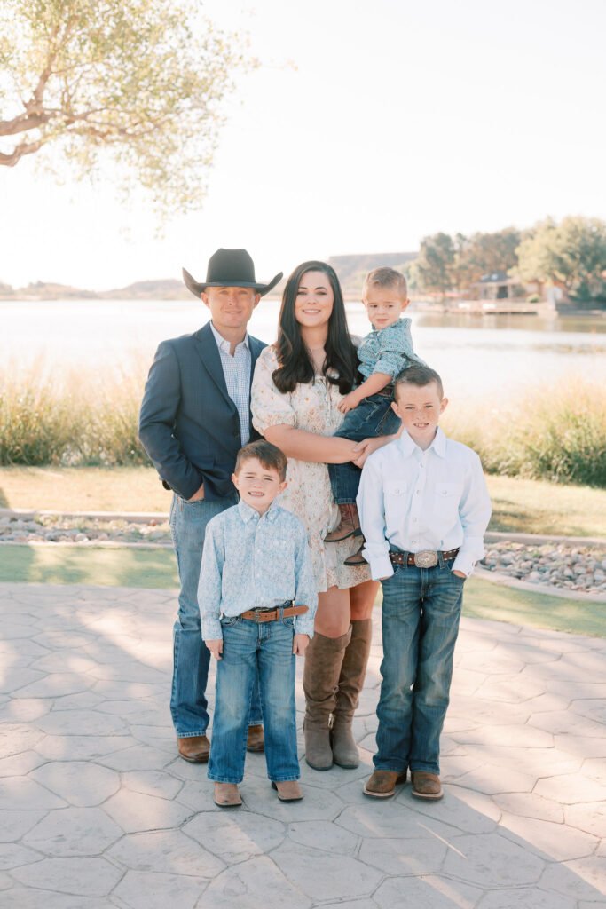 Family poses for portraits in front of Abilene photographer